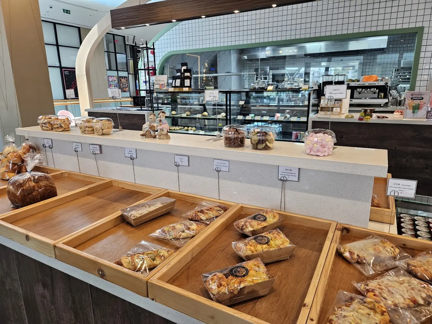 Deli Bonbons bread shelves with buns and loaves under the display lights